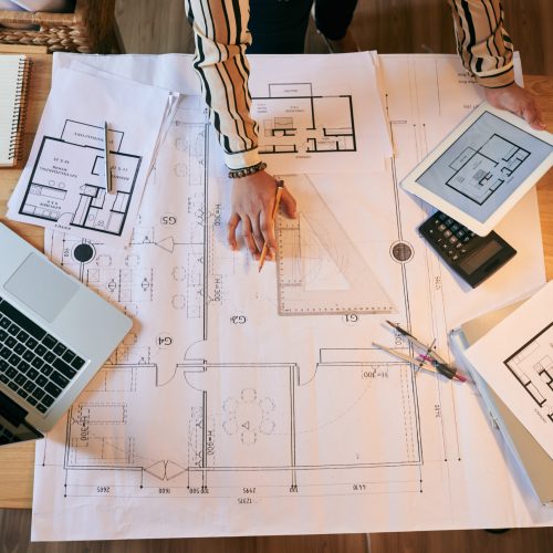 Female architect working on plan of the building, view from above
